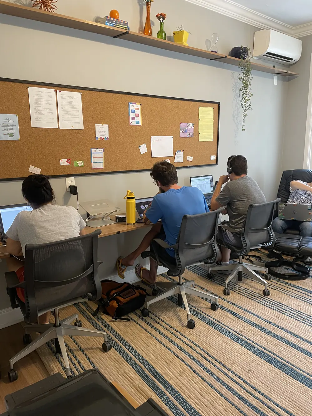Adultos trabalhando em notebooks na sala de coworking da Lumicá.